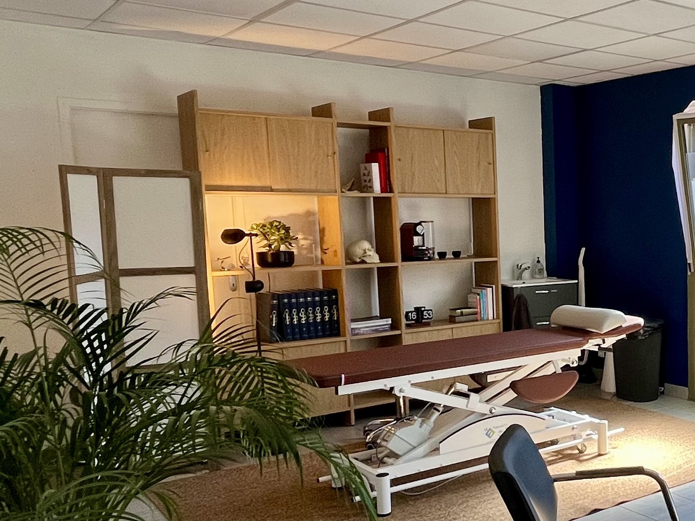 Salle de soin du cabinet d'ostéopathie, avec la table de traitement