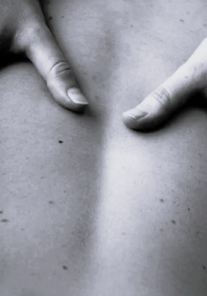 Traitement manuel : les mains du praticien sur le dos d'un patient